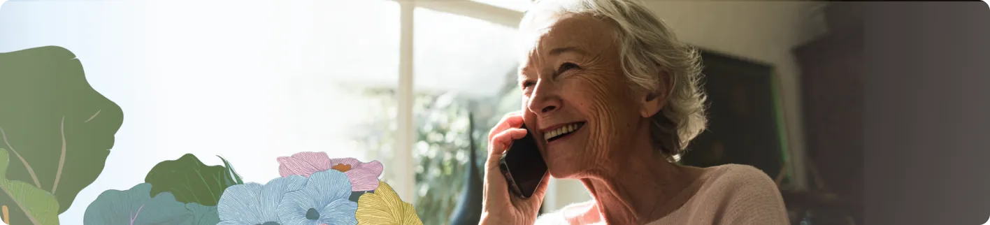 An older adult smiling while talking on the phone